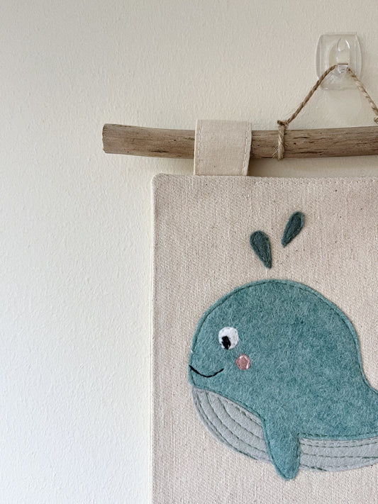 Wall hanging with a whale design on a neutral background